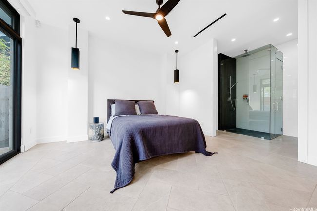 Second Bedroom with full bathroom and closet space, central a/c, ceiling fan, and door to left leads to private lanai for this bedroom only. Bathroom to the right has a toilet behind a door for privacy. Sink and large mirror to the right, not visible in this photo, please see matterport tour. | Image 13