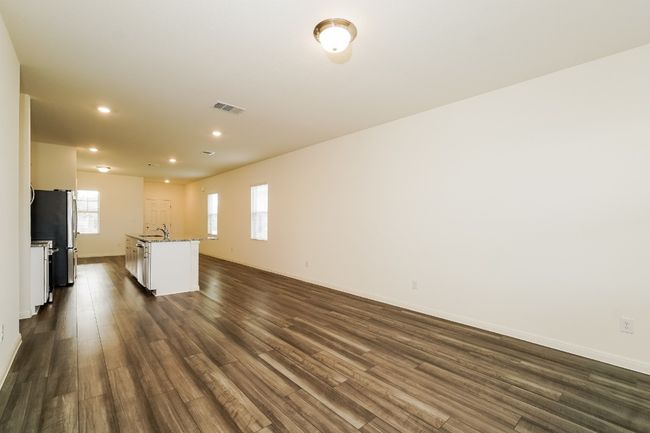 Unfurnished living room featuring recessed lighting and dark wood-style flooring | Image 7