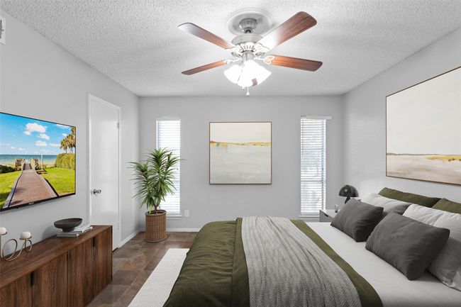 Bedroom with baseboards, a textured ceiling, ceiling fan, and stone finish floor | Image 23