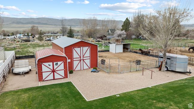 View of barn featuring a lawn, an exterior structure, fence, and a mountain view | Image 37