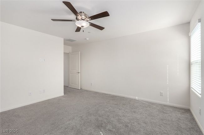 Empty room featuring light carpet, baseboards, a ceiling fan, and visible vents | Image 14