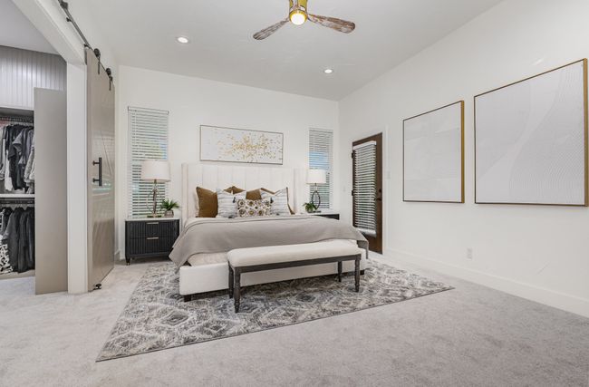 Bedroom with light colored carpet, a barn door, a closet, ceiling fan, and recessed lighting | Image 16