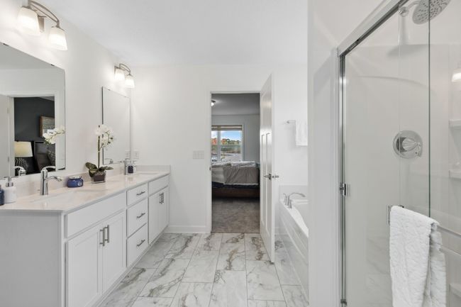 Photo is of the actual model. An extension of the primary bedroom, this private and spacious bath contains a double-vanity, a soaking tub, and a separate shower. | Image 16