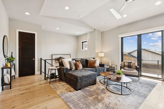 Living area featuring light wood-type flooring, lofted ceiling, a skylight, and recessed lighting | Image 12