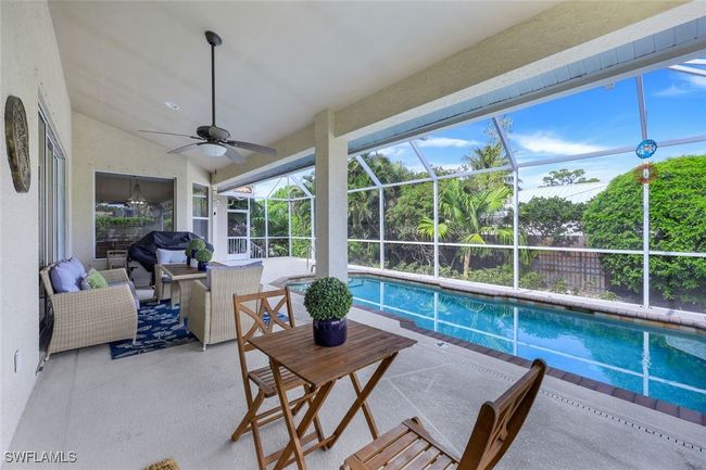 View of pool with a lanai, a bar, an outdoor hangout area, area for grilling, and a patio | Image 19