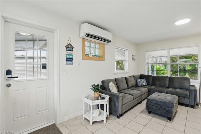 Living room with a wall unit AC and light tile patterned flooring | Image 16