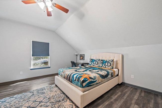Bedroom with lofted ceiling, ceiling fan, baseboards, and wood finished floors | Image 21