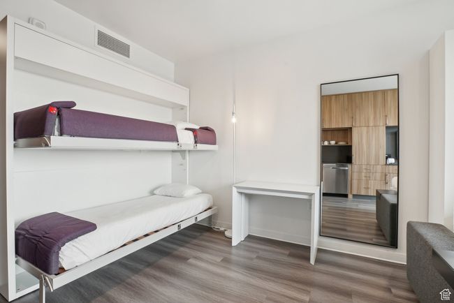 Bedroom with wood finished floors and visible vents | Image 12