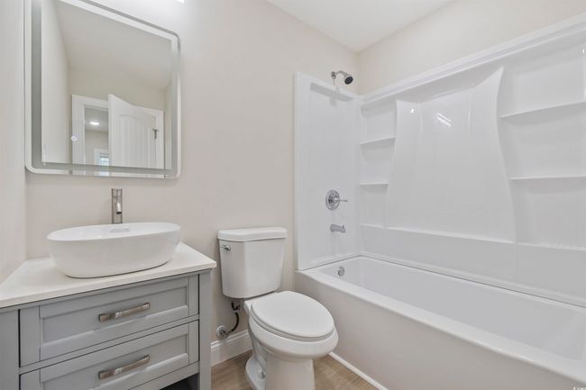 Bathroom featuring vanity, toilet, shower / tub combination, wood finished floors, and baseboards | Image 35
