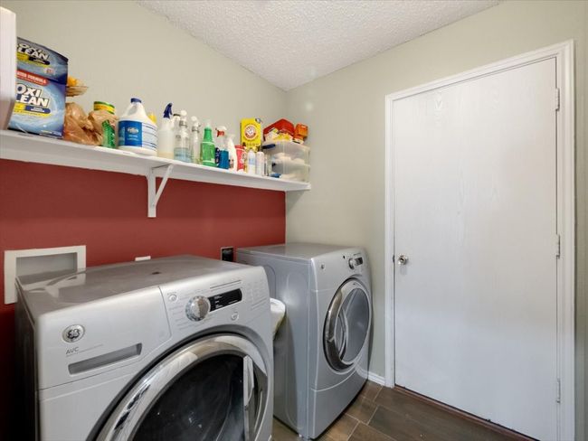 Washroom with a textured ceiling and washer and dryer | Image 14