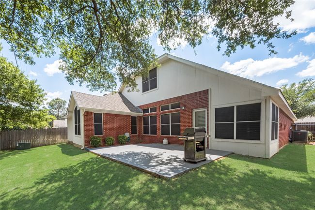 Back of property featuring a patio area, central AC unit, brick siding, and roof with shingles | Image 36