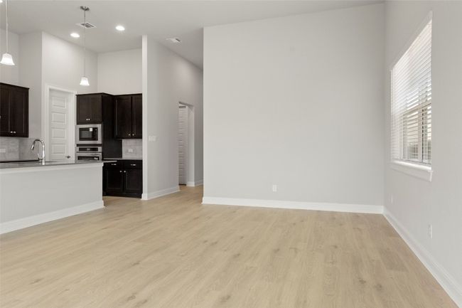 Kitchen featuring tasteful backsplash, light wood-type flooring, stainless steel oven, open floor plan, and built in microwave | Image 16