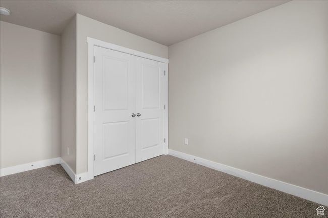 Unfurnished bedroom with carpet flooring, baseboards, and a closet | Image 32