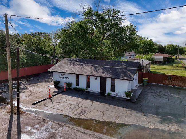 View of front facade featuring brick siding, fence, and roof with shingles | Image 4