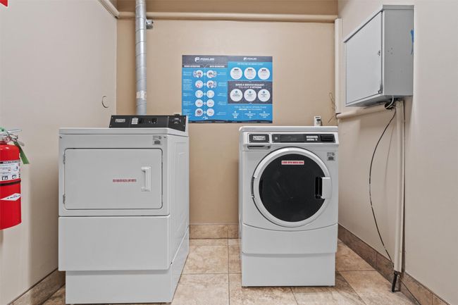 Laundry room featuring washer and clothes dryer and light tile patterned floors | Image 17