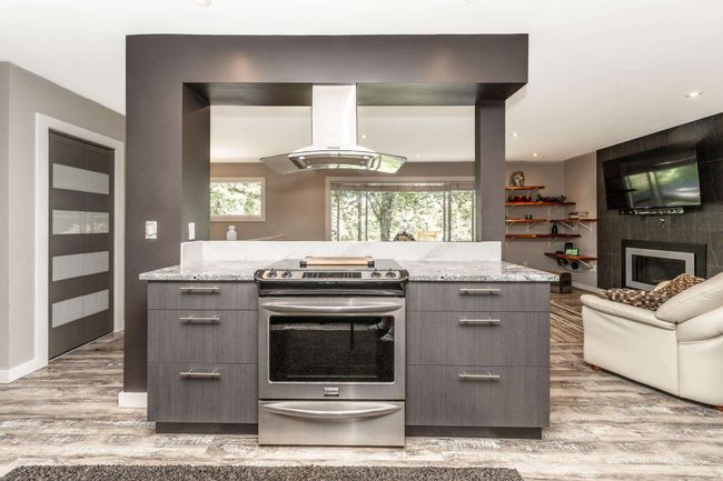 Kitchen featuring stainless steel range with electric cooktop, island exhaust hood, modern cabinets, gray cabinetry, and recessed lighting | Image 8