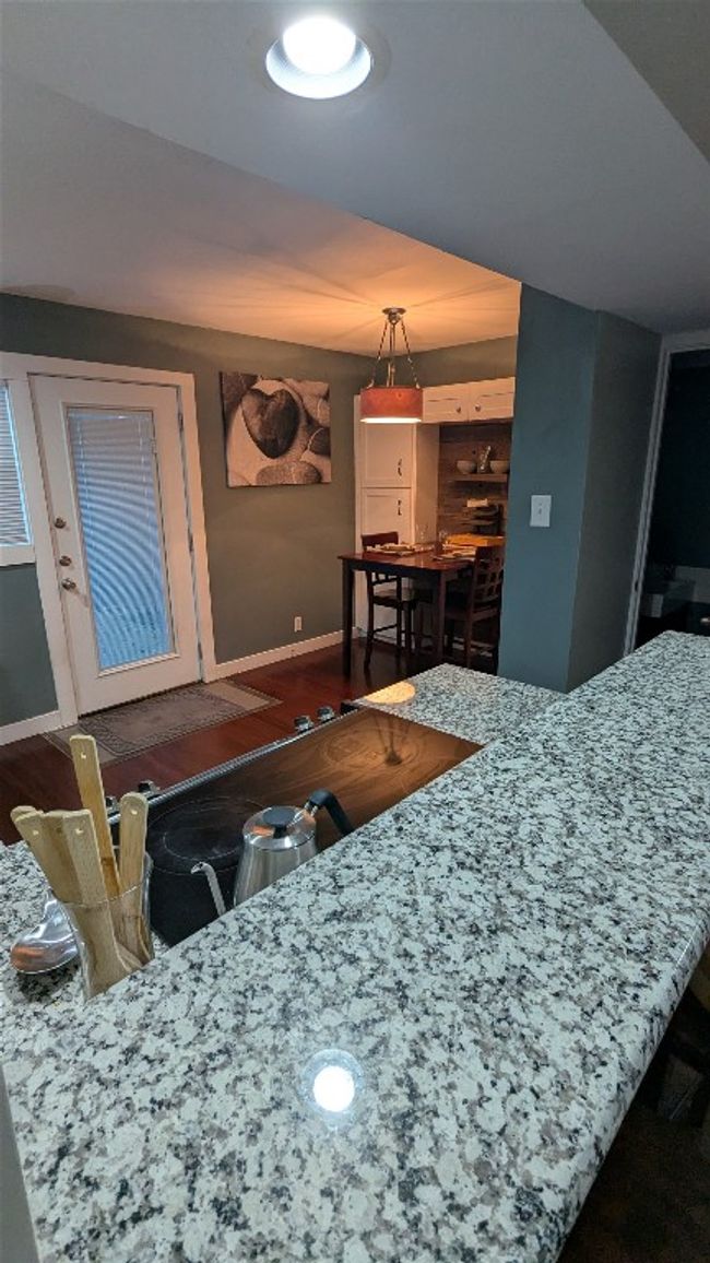 Kitchen featuring baseboards, decorative light fixtures, and light stone countertops | Image 12