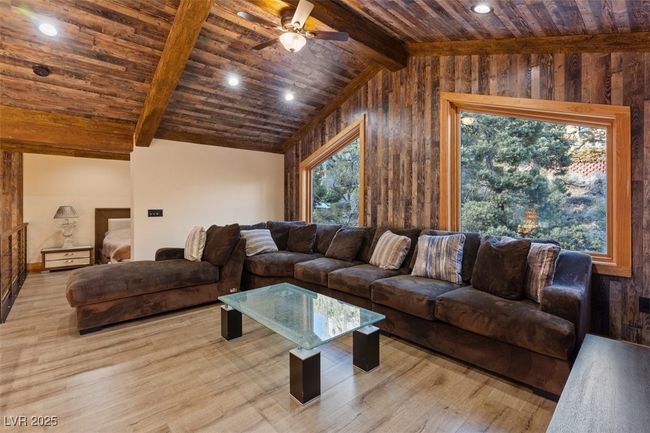 Living room with a ceiling fan, wood ceiling, vaulted ceiling with beams, and wood finished floors | Image 19