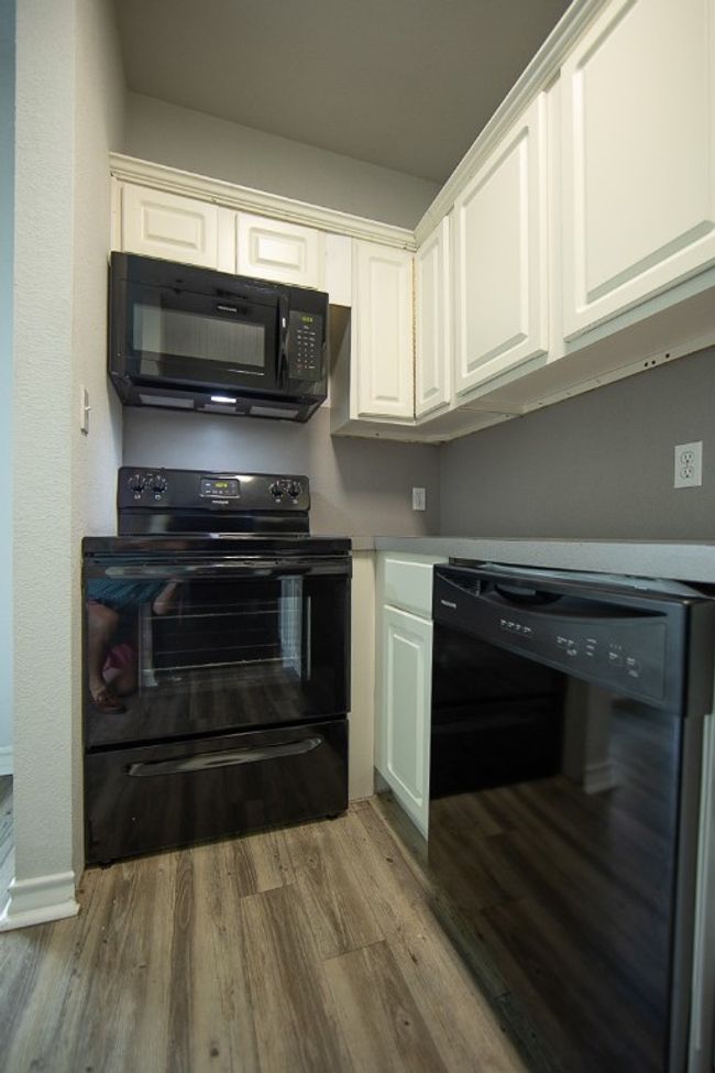 Kitchen featuring black appliances, wood finished floors, and white cabinets | Image 10