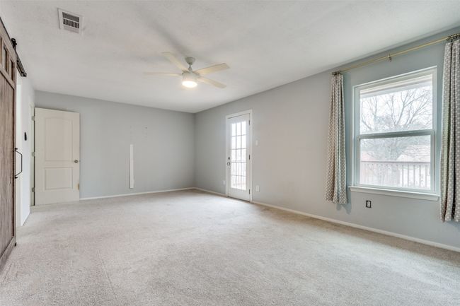 Carpeted spare room with ceiling fan and a barn door | Image 17