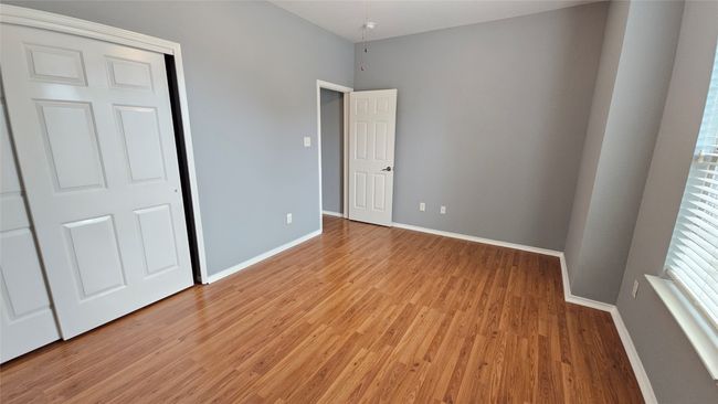 Unfurnished bedroom featuring light wood-type flooring and baseboards | Image 8