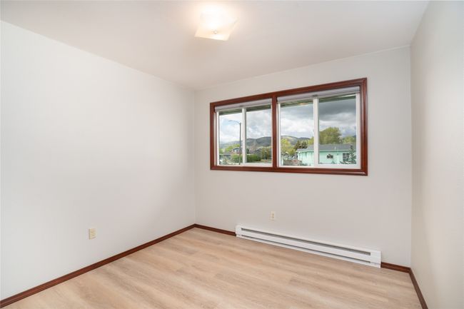 Empty room featuring a baseboard radiator, light wood-type flooring, and baseboards | Image 15