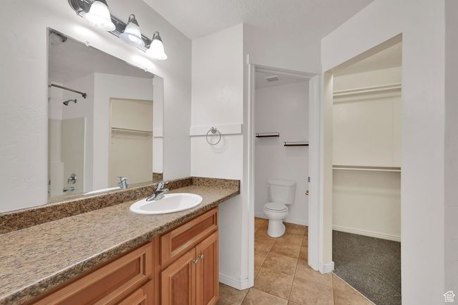 Full bath with vanity, tile patterned flooring, a walk in closet, and a shower | Image 21