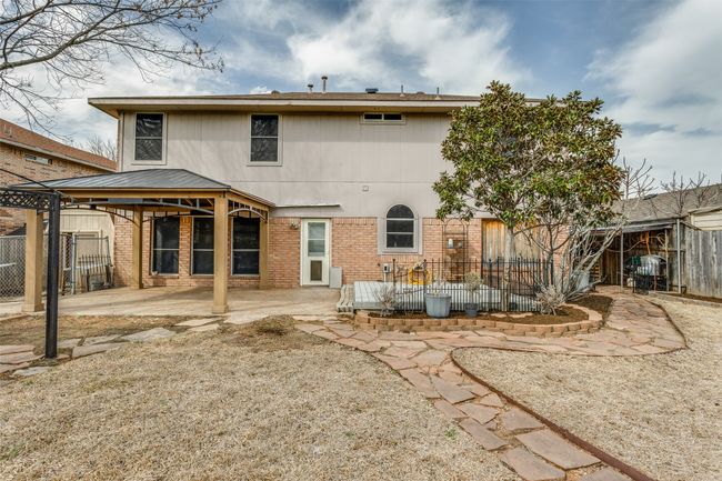 Rear view of house with a gazebo, a patio, brick siding, and fence | Image 25