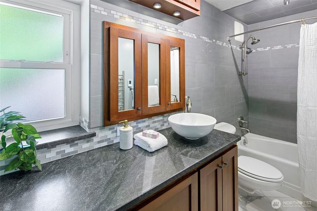 The updated and luxurious bath with cherry cabinetry, radiant heated floors and a wall mount towel warmer | Image 20