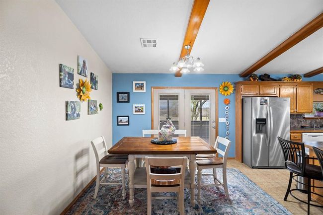 Dining space with a notable chandelier, beam ceiling, baseboards, and visible vents | Image 23