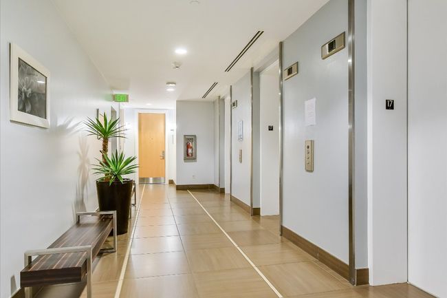 Hallway with light tile patterned floors and baseboards | Image 22