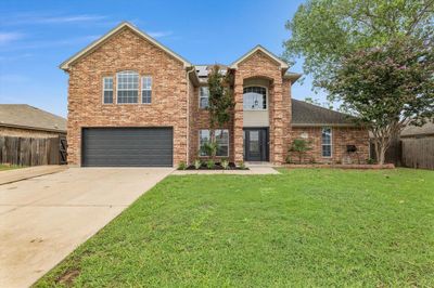 View of property featuring a front yard and a garage | Image 1