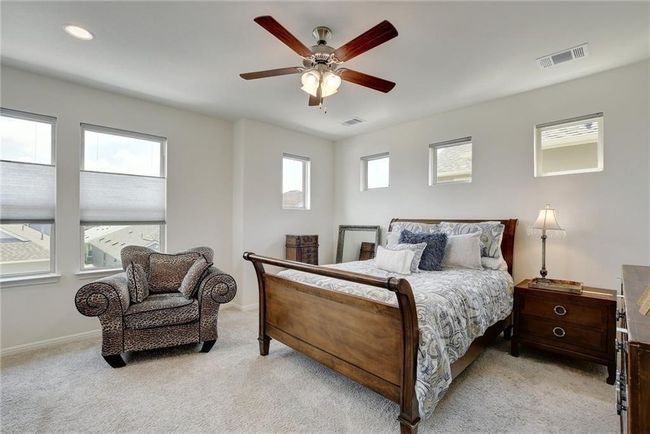 Bedroom with light colored carpet, ceiling fan, and baseboards | Image 18