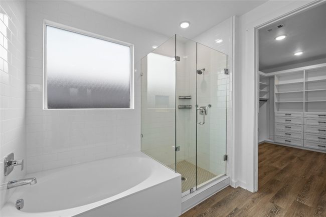 Bathroom featuring a bath, a shower stall, wood finished floors, recessed lighting, and a spacious closet | Image 13