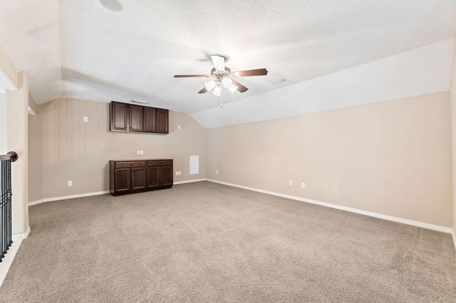 Bonus room upstairs with ceiling fan and built-in cabinets. Perfect for a play room, poker area, office space, and many other possibilities! | Image 35