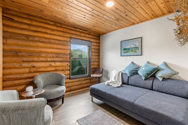 Living room with wood ceiling, wood finished floors, and log walls | Image 20