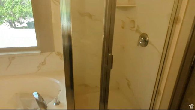 Bathroom featuring a shower stall and a bath | Image 32