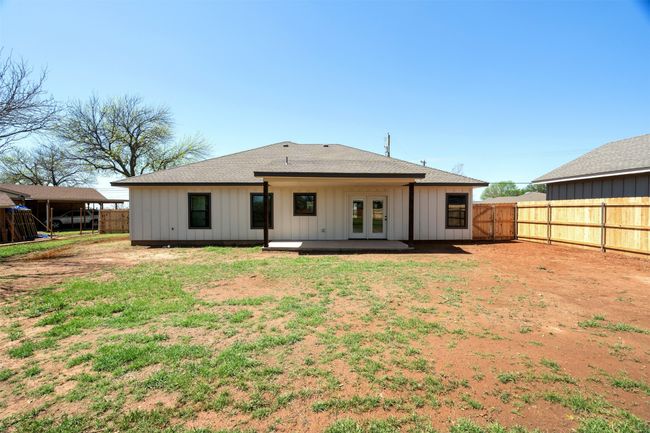 Back of property featuring board and batten siding, french doors, a fenced backyard, a patio, and roof with shingles | Image 28