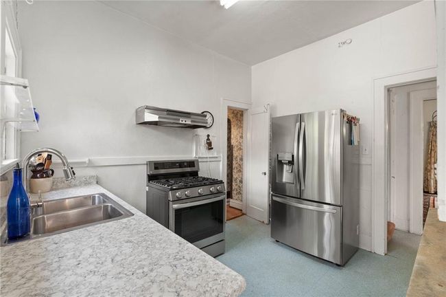 Kitchen with light countertops, a sink, and appliances with stainless steel finishes. | Image 11