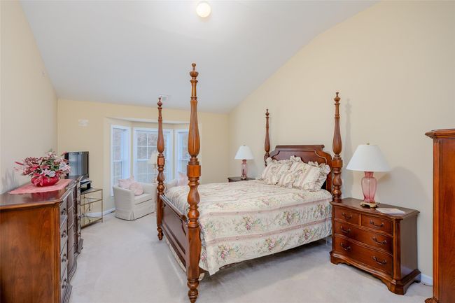 Bedroom featuring vaulted ceiling and light colored carpet | Image 21