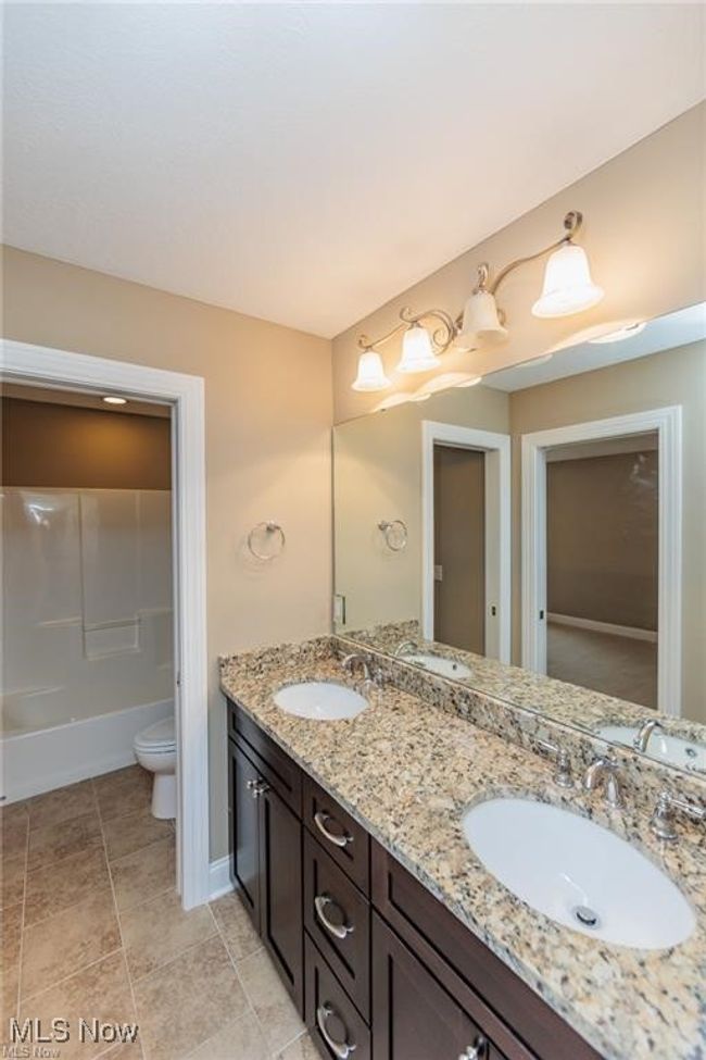 Full bath featuring toilet, double vanity, and a sink | Image 5