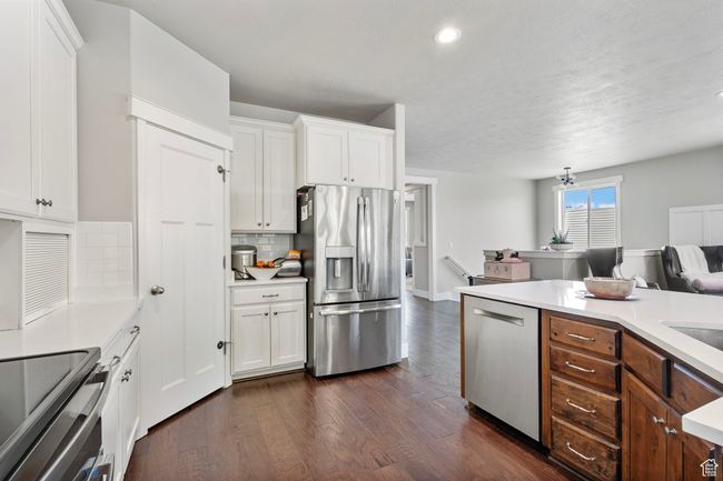 Kitchen with appliances with stainless steel finishes, dark wood-type flooring, light countertops, white cabinetry, and recessed lighting | Image 12