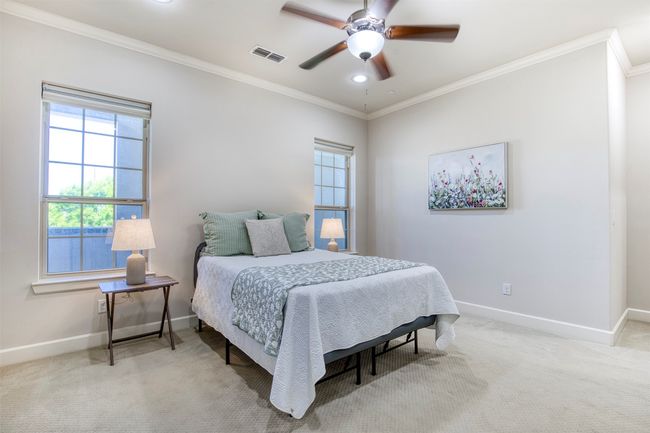 Spacious primary suite with crown molding and natural light. | Image 17