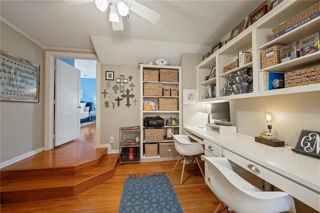 Office space featuring built in study area, light wood-style floors, ceiling fan, ornamental molding, and baseboards | Image 26