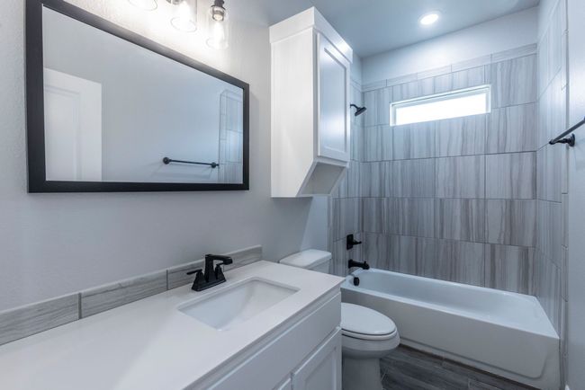 Full bathroom with vanity, washtub / shower combination, and wood finished floors | Image 18