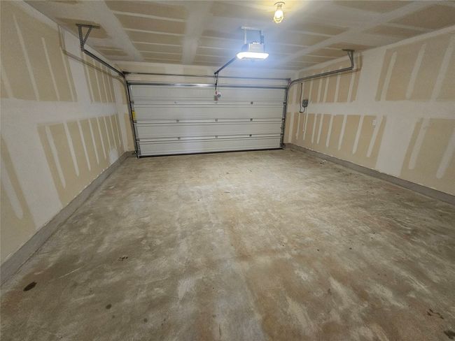 Garage featuring a garage door opener and baseboards | Image 30