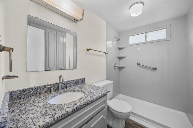 Bathroom featuring a shower, vanity, a textured ceiling, toilet, and wood finished floors | Image 23