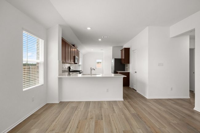 Kitchen featuring a sink, light wood-type flooring, stainless steel appliances, a peninsula, and recessed lighting | Image 5