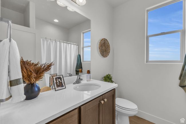 Bathroom with wood-type flooring, vanity, toilet, and curtained shower | Image 29