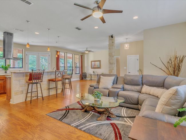 Living area featuring ceiling fan, light wood-style floors, recessed lighting, and decorative columns | Image 9